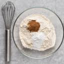 Whisker and a bowlful of flour, cinnamon and baking powder