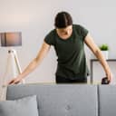 Woman measuring the headrest of a sofa
