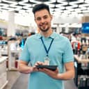 A salesman holding a tablet in an electronics store