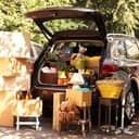 packed car trunk with moving boxes and other items, parked outside