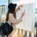 woman at a bus stop looking at a public transport map on her phone