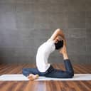 Man doing yoga on the floormat indoors