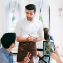 attentive waiter taking order from a young couple at a lively restaurant