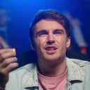 close-up of a shocked man reacting negatively to a bad film in a movie theater while eating popcorn