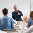 professor pointing at a student with a raised hand in a classroom