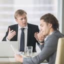 A manager angry at a worker during a meeting
