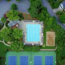 An aerial view of a recreational center, with its swimming pool and tennis court.