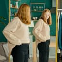 A young girl checking herself in the mirror