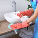 A woman cleaning a sink in the bathroom