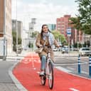 A young woman riding a bicycle down a bicycle lane