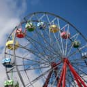 Part of a Ferris wheel structure in the amusement park against blue sky.