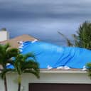 A blue tarp covering the damaged part of a roof
