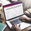 A student submitting a Scholarship Application online using a laptop