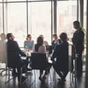 a group of business professionals engaged in a presentation during the meeting in a modern conference room