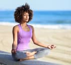 Woman meditating near the beach