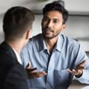 close-up of a young male entrepreneur discussing project details with a business partner at an office workspace