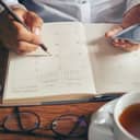 A person writing a note in their calendar
