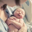 Closeup of a newborn being held by their mother