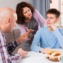 A disinterested young man being scolded by his parents