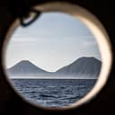 View of the seaside and mountains from a cabin window