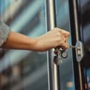 Close up of woman unlocking entrance door with a key. Person using key and locking apartment door.