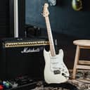 Electric guitar resting against an amplifier in a studio