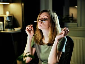 A bored young woman playing with her pen