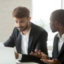Two businessmen arguing over errors in a business document after feedback.