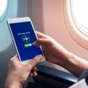 Person switching their smartphone to airplane mode inside an airplane