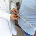 Doctor measuring the circumference of a person's waist