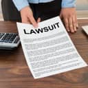 Lawsuit paper being presented by a person on the table