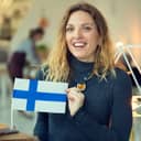 Smiling woman holding up a stick flag of Finland