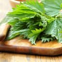 close-up of fresh stinging nettle leaves placed on a cutting board