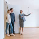 Realtor showing a house to a young couple.