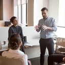 A man giving explanations to his coworkers