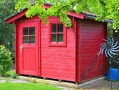 A red wooden shed in a garden