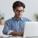 Serious businessman writing a message on his laptop