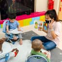 Female teacher wearing a face mask entertaining toddlers at a daycare center