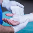Nurse bandaging patient's hand