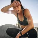 a woman wiping sweat from her forehead after training session