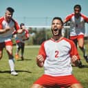 Team, success and winner by soccer player celebration during game at soccer field, happy, cheering and victory. Sport, achievement and goal by football team running and celebrating football field win