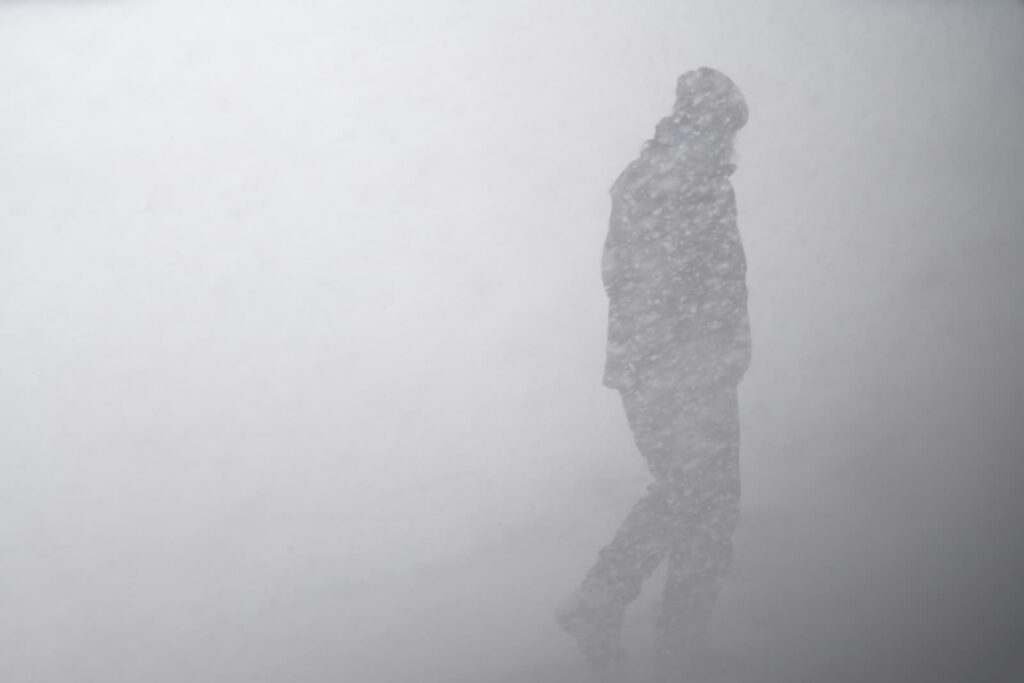 A person walking through a heavy snow storm or blizzard