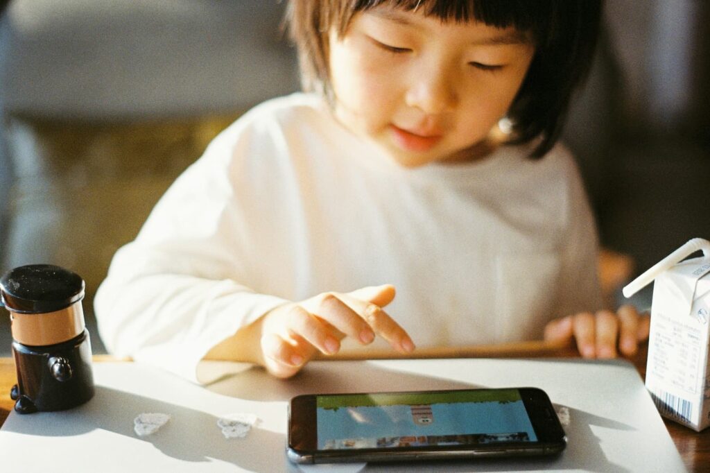 A little girl playing a game on a smartphone