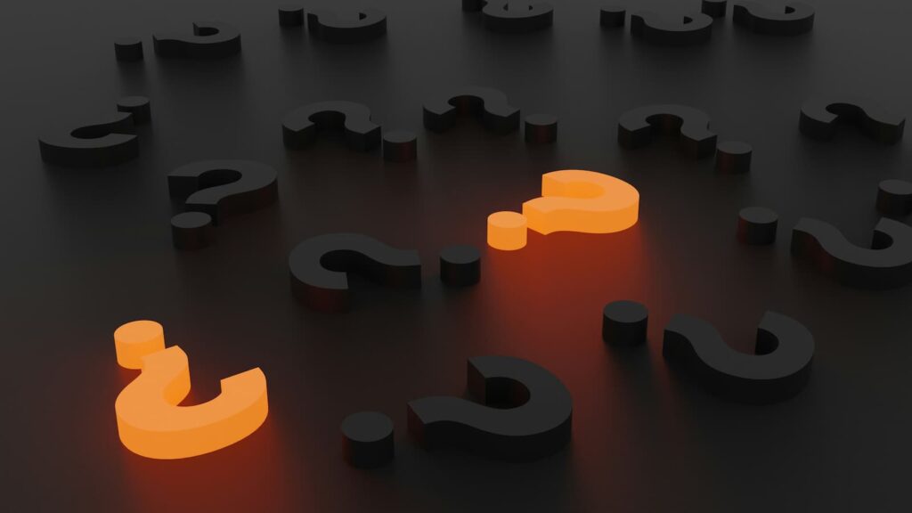Two orange question marks among a group of black question marks