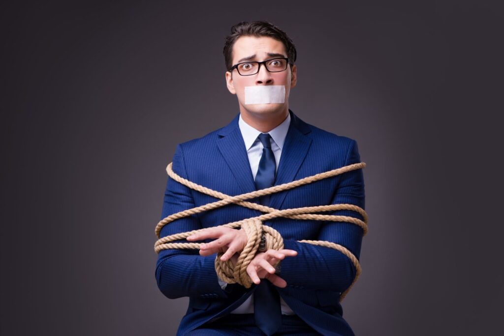 A man in a business suit tied up with rope