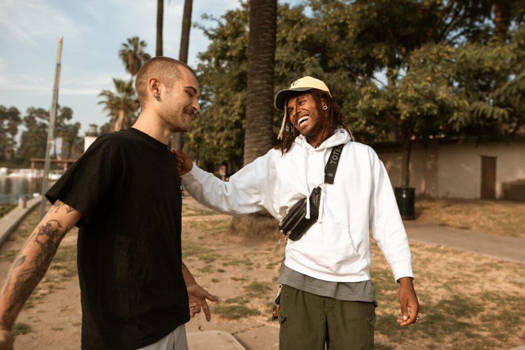 Two young men smiling while having a conversation
