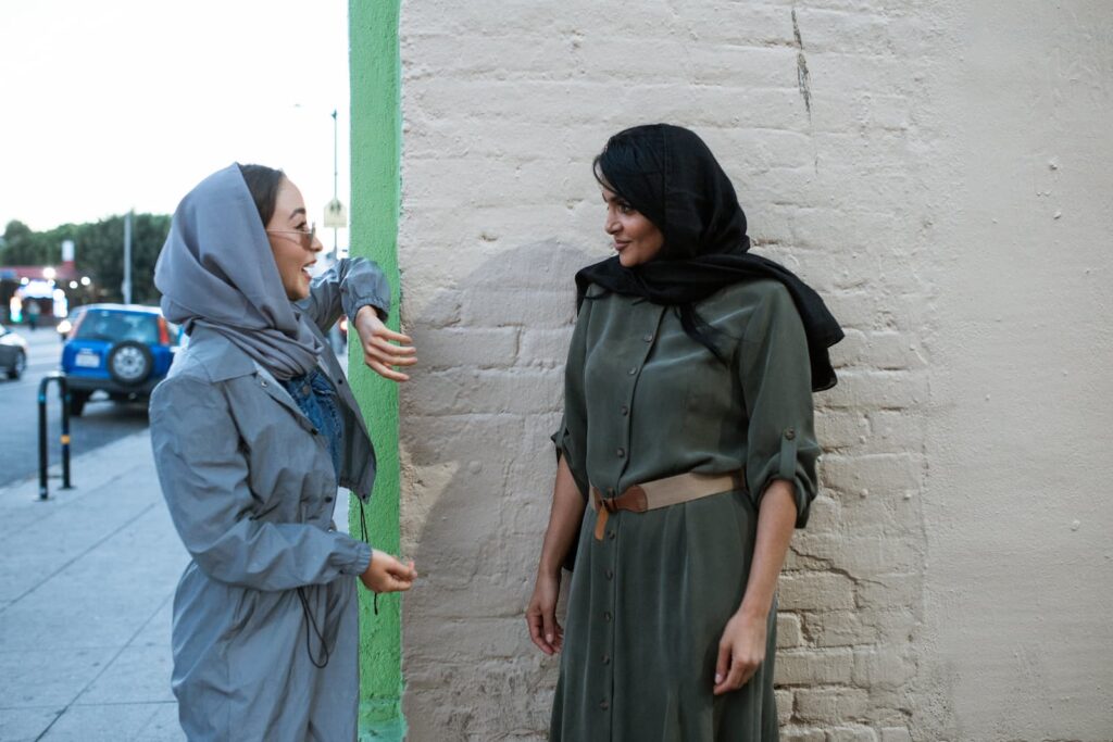Two women having a conversation while standing on the street