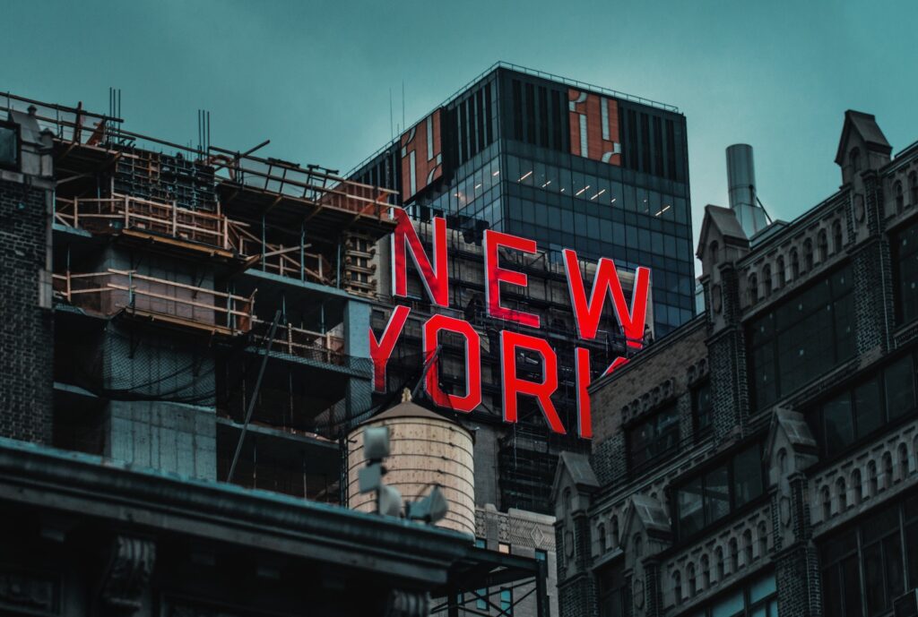 A "NEW YORK" sign visible among many buildings in a busy city scene