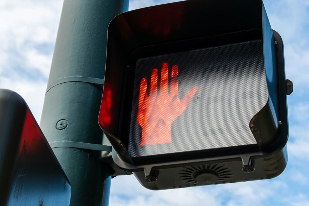 A pedestrian traffic signal with the "stop" hand lit