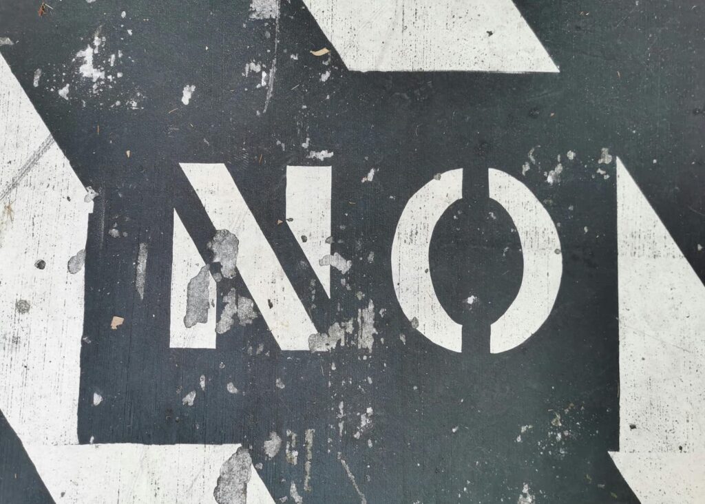 "NO" painted in white on a concrete surface